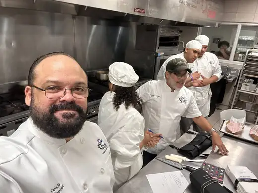 Professor Erasmo Rodríguez with students during a culinary learning experience.