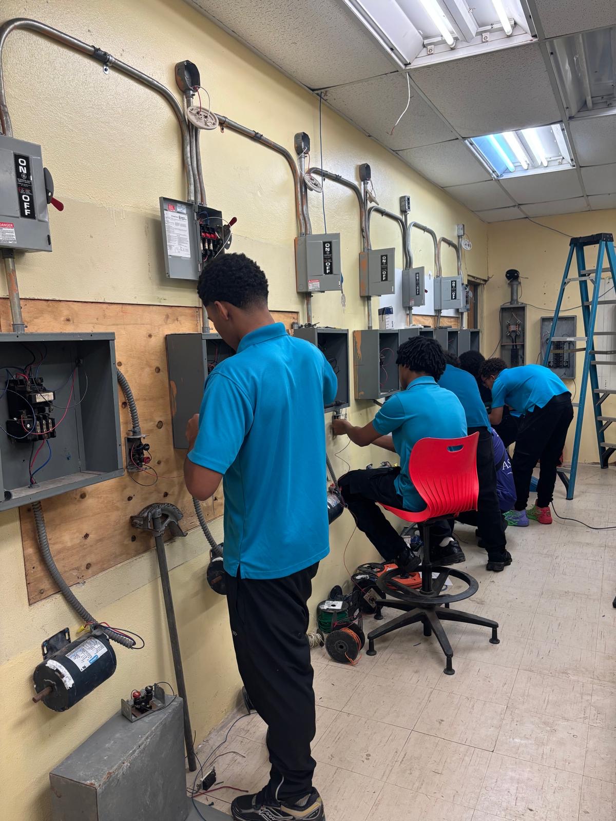 Students working on electrical installations and lab panels